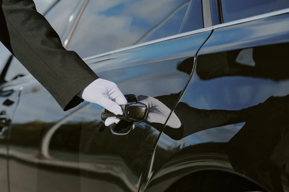 White-gloved chauffeur opening a car door