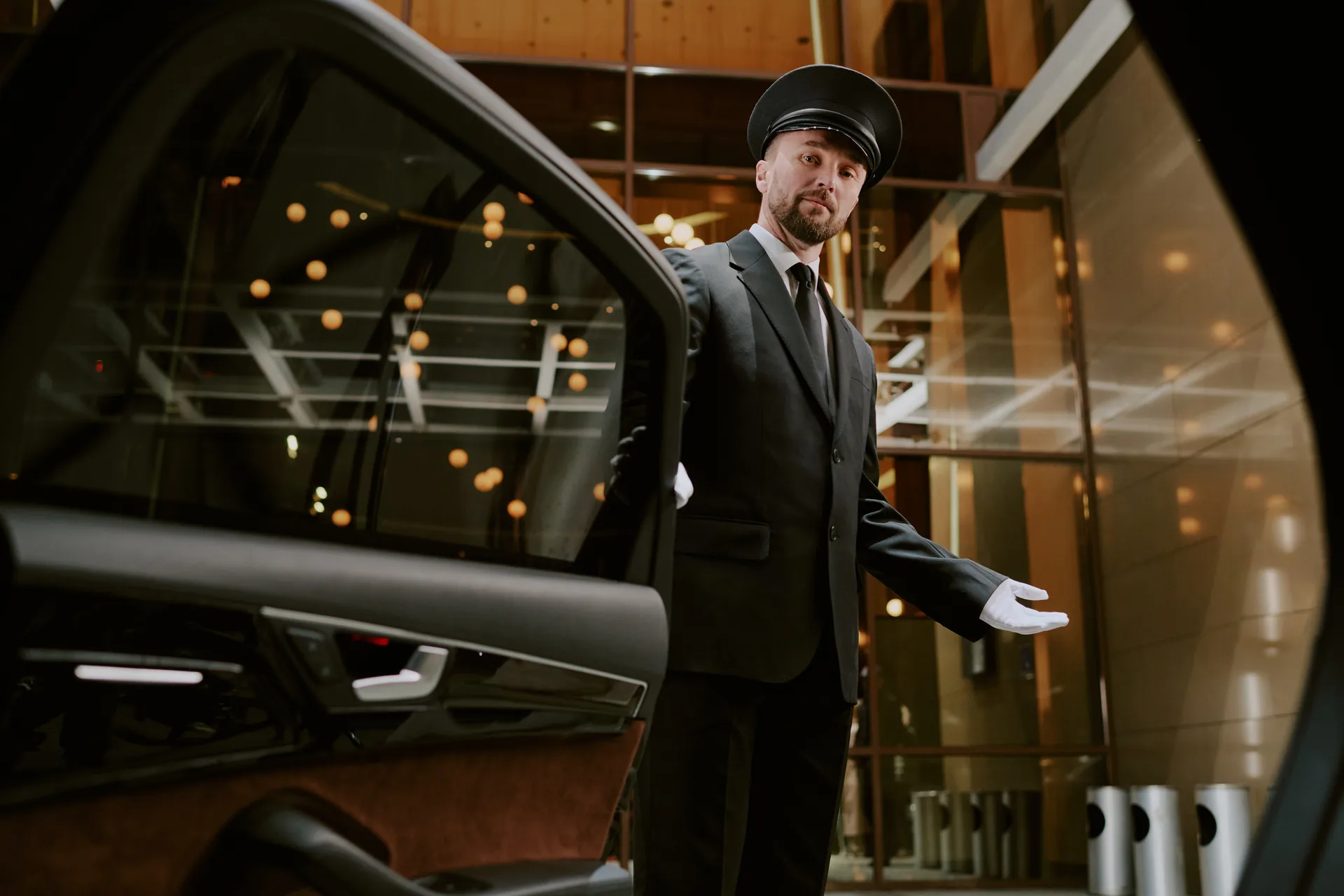 Chauffeur welcoming a passenger at an open car door
