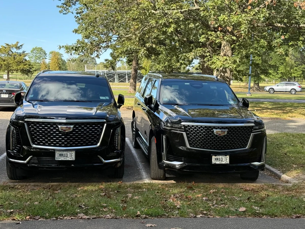 Two black Cadillac Escalade SUVs parked together